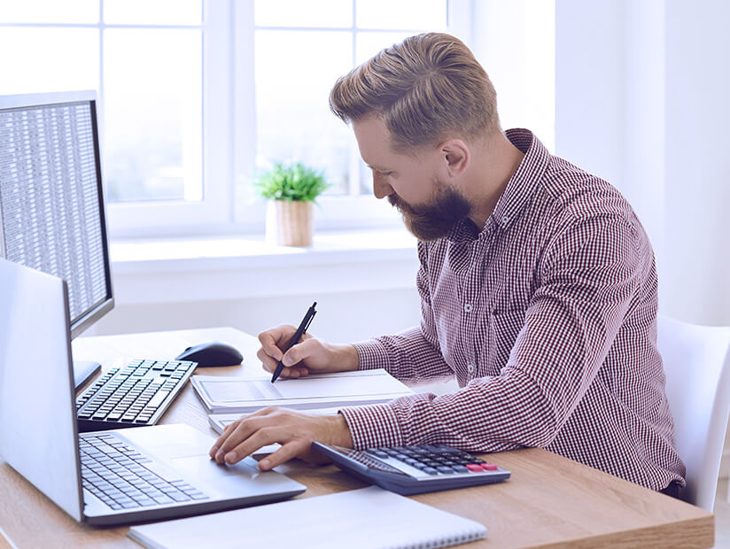 finance professional man sitting in office workplace doing multiple tasks