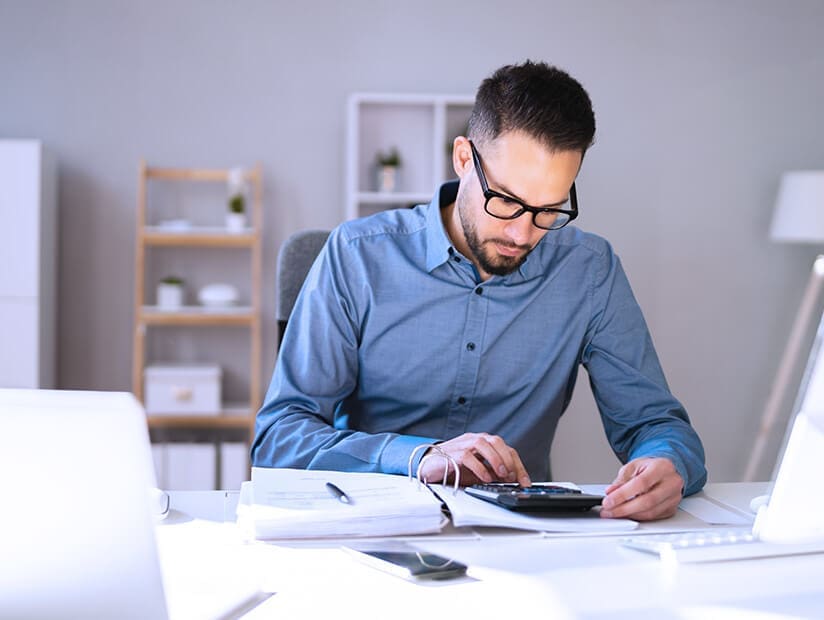 male accountant working on calculator