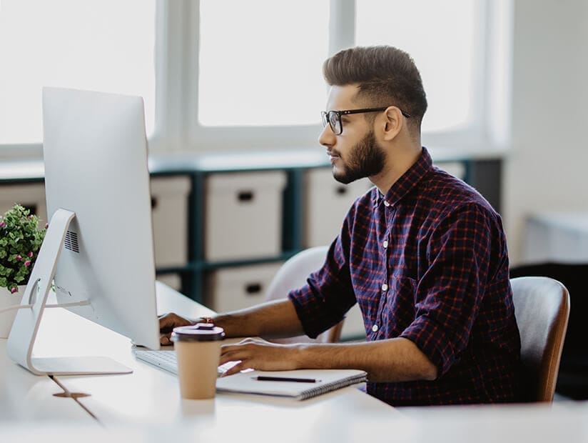 south asian accountant working at desktop computer