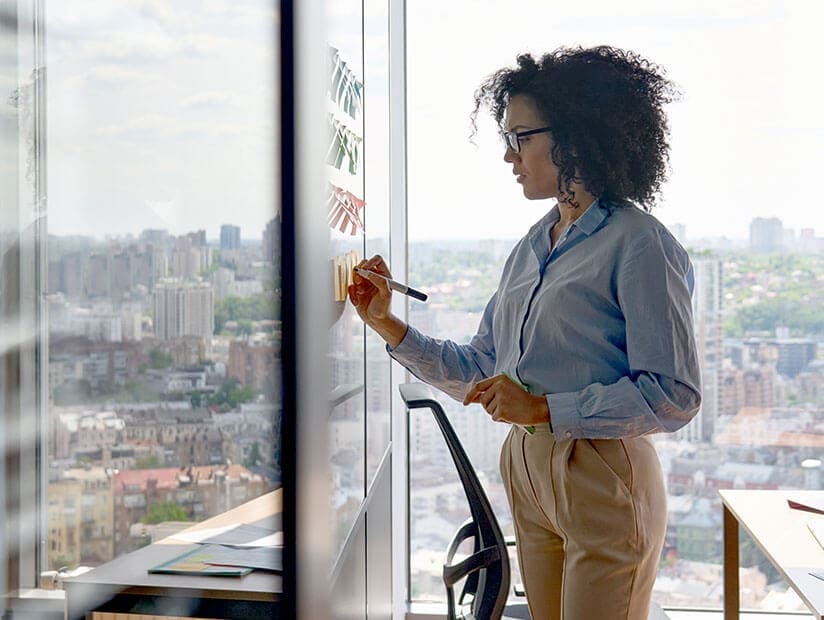 woman in office writing on whiteboard