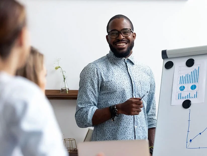 Chapter 05 - Upskilling & Reskilling in the Age of AI 1 man presenting charts on whiteboard 1